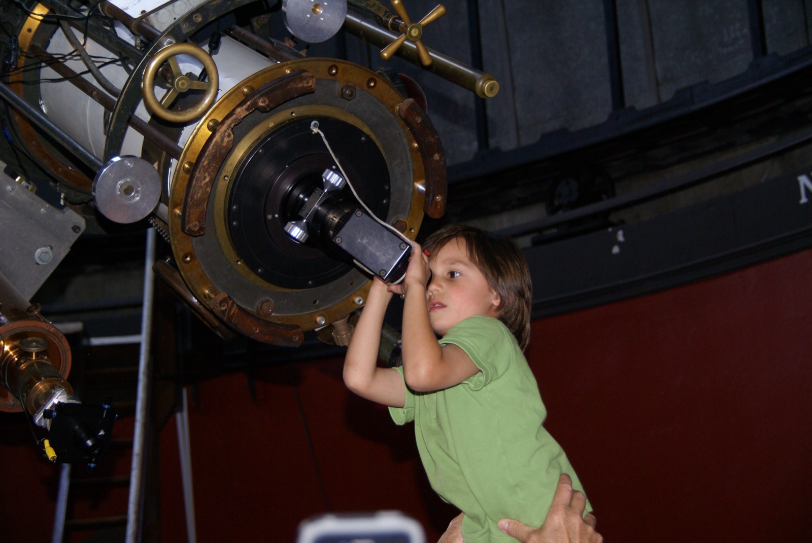 A child looking into a telescope at an observatory